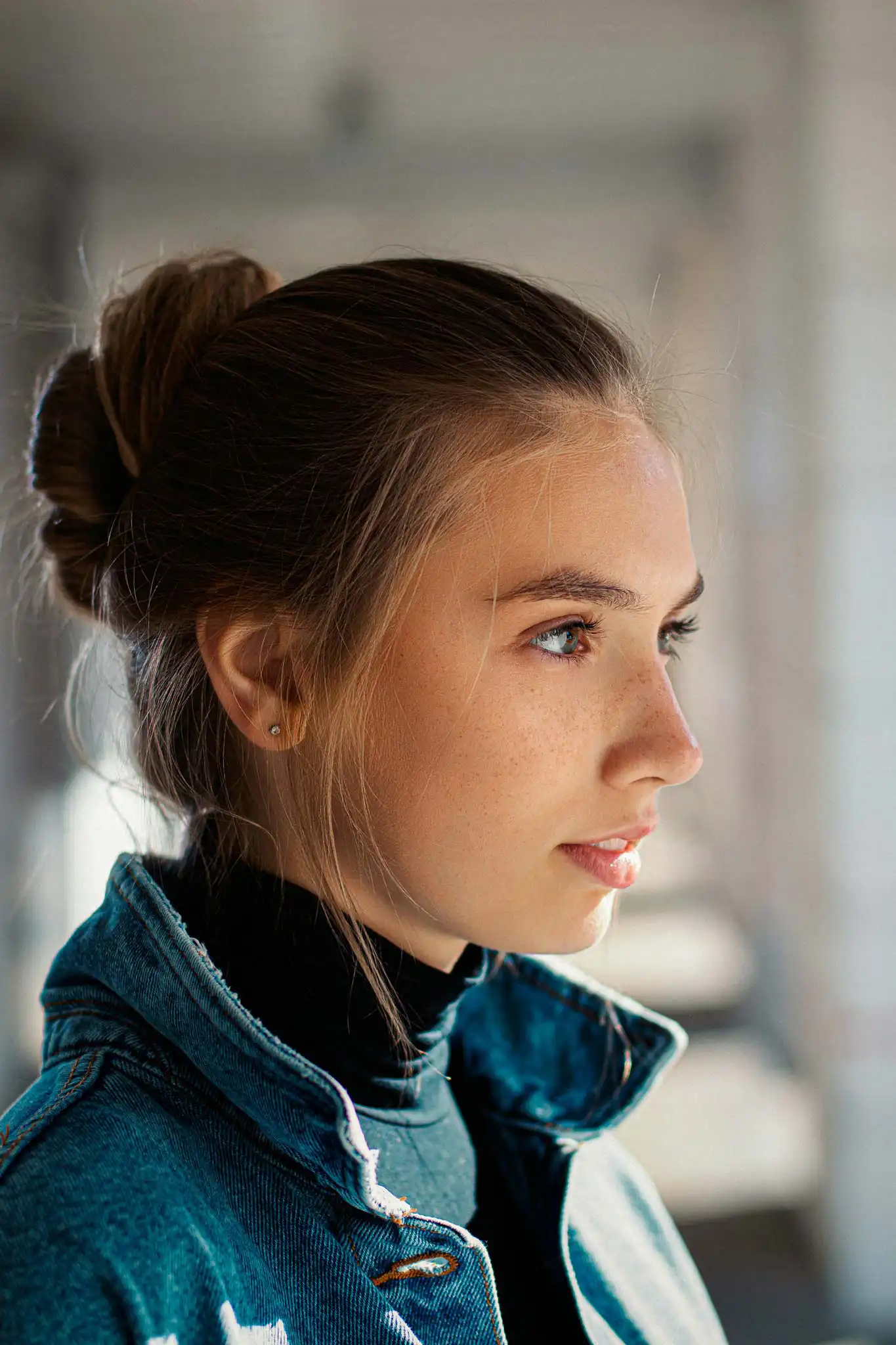 Portrait of a woman in a denim jacket looking off to the side
