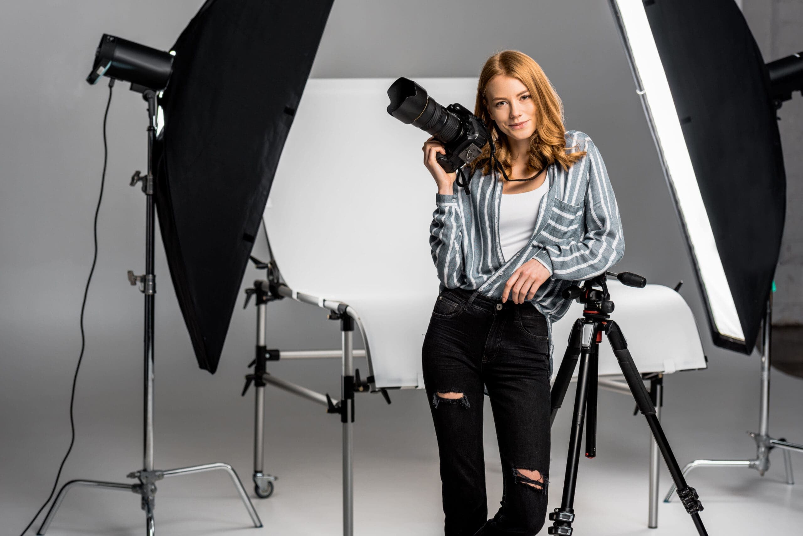 Photographer working with studio lighting equipment during a portrait shoot